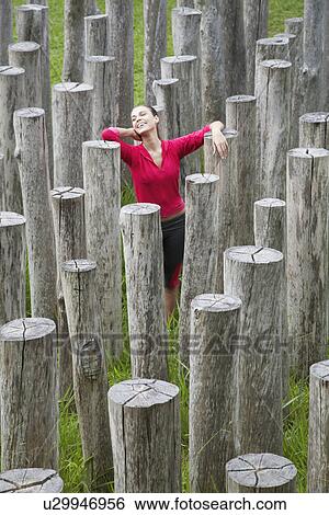 Stock Photograph - Young woman surrounded by stumps, high angle view. Fotosearch