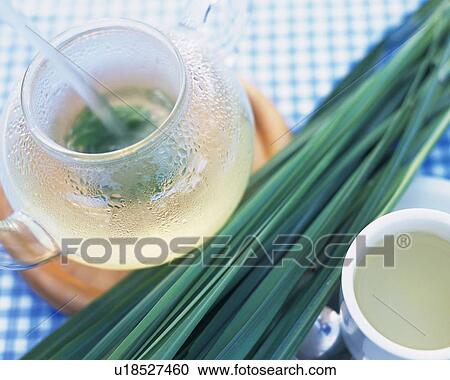 Stock Image - Lemongrass in a Tea Pot, Next to a Cup, High Angle View. Fotosearch