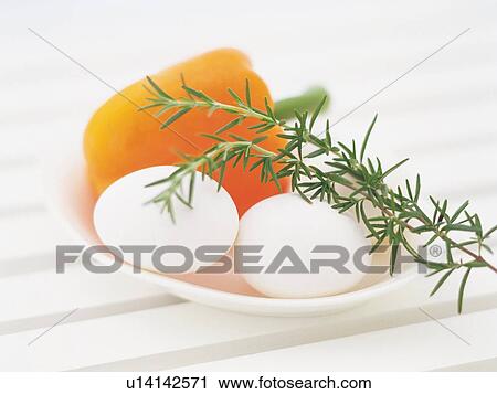 Stock Image - Rosemary Lying in a White Bowl WithEggs and a Yellow Bell pepper, . Fotosearch