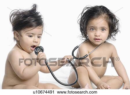 Stock Image - Close-up of a baby boy and his sister playing with a stethoscope. Fotosearch