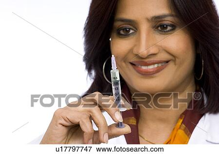 Stock Photo - Close-up of a female doctor holding an injection. Fotosearch