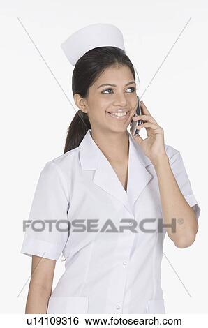 Close-up of a female nurse talking on a mobile phone View Large Photo Image Stock Photograph - Close-up of a female nurse talking on a mobile phone. Fotosearch