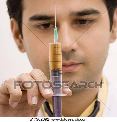 Close-up of a male doctor holding a syringe View Large Photo Image Stock Image - Close-up of a male doctor holding a syringe. Fotosearch