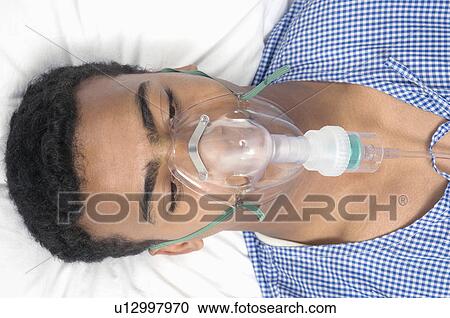 Stock Image - Close-up of a patient wearing an oxygen mask. Fotosearch