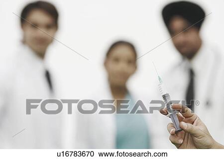 Close-up of a person's hand holding a syringe View Large Photo Image Stock Image - Close-up of a person's hand holding a syringe. Fotosearch