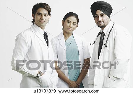 Close-up of two male doctors and a female doctor standing together View Large Photo Image Stock Photo - Close-up of two male doctors and a female doctor standing together. Fotosearch