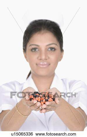 Portrait of a female nurse holding capsules View Large Photo Image Stock Photograph - Portrait of a female nurse holding capsules. Fotosearch