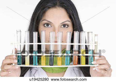 Stock Image - Portrait of a female technician holding a test tube rack. Fotosearch