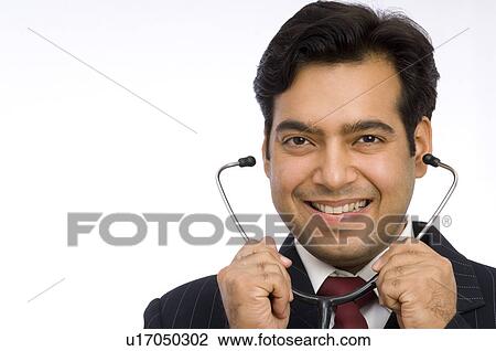 Portrait of a male doctor holding a stethoscope View Large Photo Image Stock Image - Portrait of a male doctor holding a stethoscope. Fotosearch