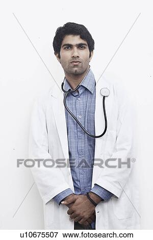 Portrait of a male doctor standing with a stethoscope around his neck View Large Photo Image Stock Photo - Portrait of a male doctor standing with a stethoscope around his neck. Fotosearch