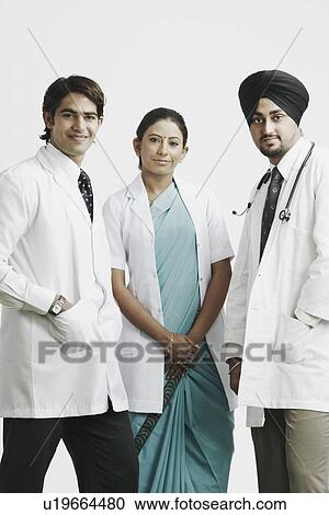 Stock Image - Portrait of two male doctors and a female doctor standing together. Fotosearch