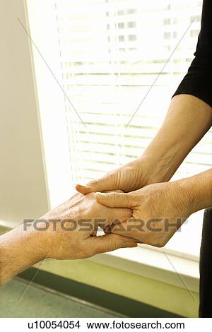 Caucasian female nurse massaging arthritic hands of elderly man at retirement community center. View Large Photo Image Picture - Caucasian female nurse massaging arthritic hands of elderly man at retirement community center.. Fotosearch