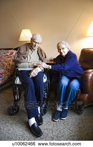 Stock Photograph - Elderly Caucasian couple in bedroom at retirement community center.. Fotosearch