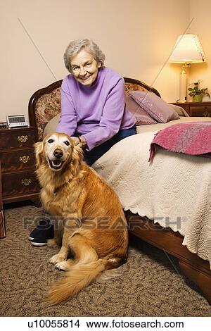 Elderly Caucasian woman and dog in her bedroom at retirement community center. View Large Photo Image Picture - Elderly Caucasian woman and dog in her bedroom at retirement community center.. Fotosearch