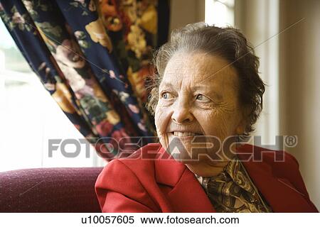 Stock Photography - Elderly Caucasian woman by window at retirement community center.. Fotosearch