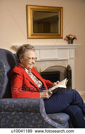 Elderly Caucasian woman reading book in chair at retirement community center. View Large Photo Image Stock Photo - Elderly Caucasian woman reading book in chair at retirement community center.. Fotosearch