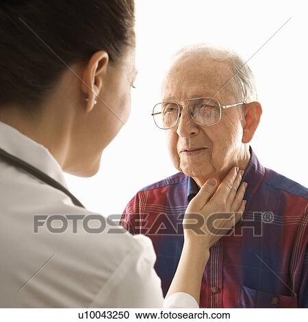Stock Image - Mid-adult Caucasian female doctor checking an elderly Caucasian male's pulse.. Fotosearch
