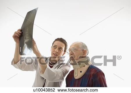 Mid-adult Caucasian female doctor showing x-ray to elderly Caucasian male in neck brace. View Large Photo Image Stock Image - Mid-adult Caucasian female doctor showing x-ray to elderly Caucasian male in neck brace.. Fotosearch
