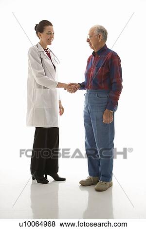 Stock Photo - Mid-adult Caucasian female doctor shaking hands with an elderly Caucasian male.. Fotosearch