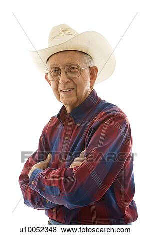 Stock Photo - Portrait of smiling Caucasion elderly man wearing plaid shirt and cowboy hat with arms crossed.. Fotosearch
