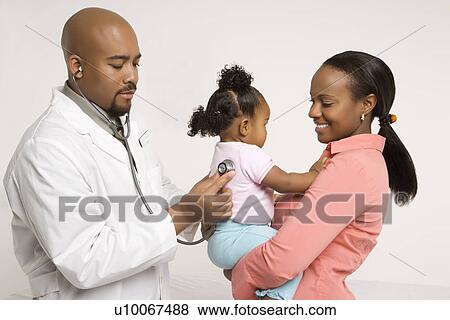African-American male pediatrician examining baby girl being held by mother. View Large Photo Image Stock Photo - African-American male pediatrician examining baby girl being held by mother.. Fotosearch
