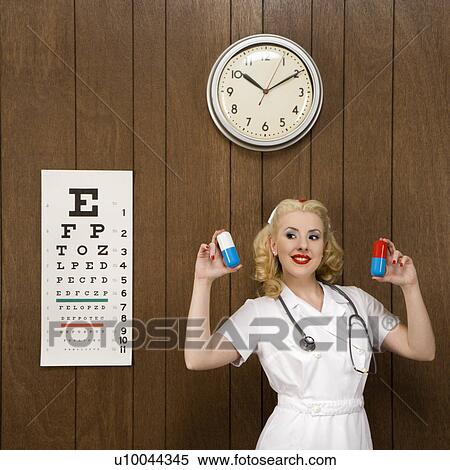 Caucasian mid-adult female nurse standing by wood paneling holding oversized pills and smiling at viewer. View Large Photo Image Stock Photography - Caucasian mid-adult female nurse standing by wood paneling holding oversized pills and smiling at viewer.. Fotosearch