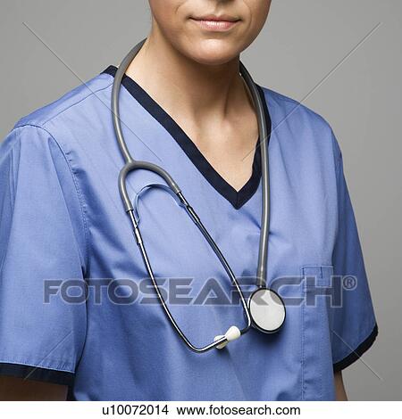 Picture - Close-up view of Caucasian woman doctor wearing scrubs with stethoscope around neck.. Fotosearch