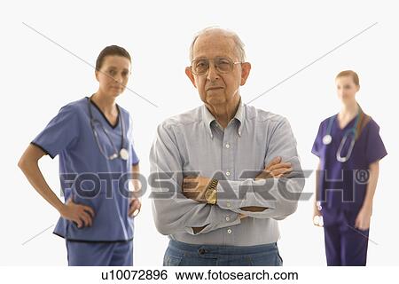 Stock Photograph - Elderly Caucasian male in foreground with two Caucasian females in the background.. Fotosearch
