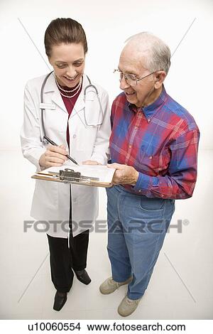 Mid-adult Caucasian female doctor showing papers to elderly Caucasian male. View Large Photo Image Picture - Mid-adult Caucasian female doctor showing papers to elderly Caucasian male.. Fotosearch