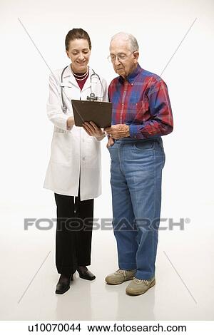Mid-adult Caucasian female doctor showing papers to elderly Caucasian male. View Large Photo Image Picture - Mid-adult Caucasian female doctor showing papers to elderly Caucasian male.. Fotosearch
