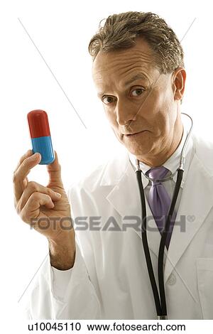 Mid-adult Caucasian male doctor holding an oversized medical pill. View Large Photo Image Stock Image - Mid-adult Caucasian male doctor holding an oversized medical pill.. Fotosearch