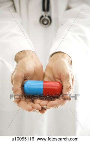 Mid-adult Caucasian male doctor holding out an oversized medical pill. View Large Photo Image Stock Photograph - Mid-adult Caucasian male doctor holding out an oversized medical pill.. Fotosearch