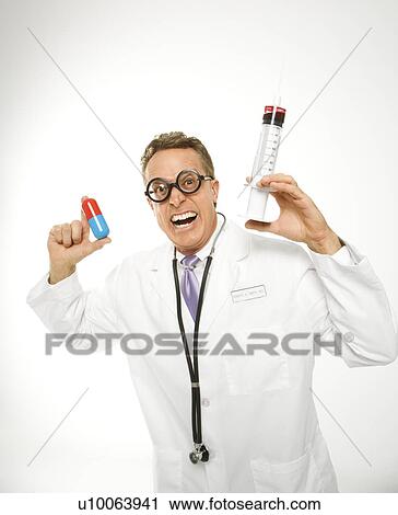 Mid-adult Caucasian male doctor wearing eyeglasses holding an oversized medical pill and syringe. View Large Photo Image Stock Image - Mid-adult Caucasian male doctor wearing eyeglasses holding an oversized medical pill and syringe.. Fotosearch