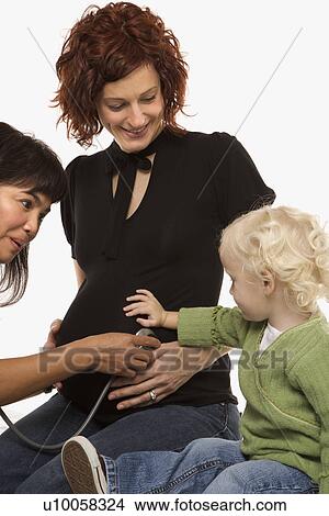 Nurse holding stethoscope on Caucasian pregnant woman's belly. View Large Photo Image Picture - Nurse holding stethoscope on Caucasian pregnant woman's belly.. Fotosearch