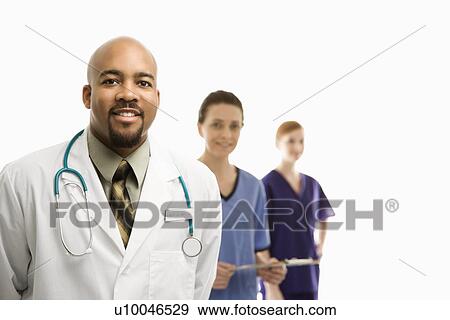 Portrait of smiling African-American man and Caucasian women medical healthcare workers in uniforms standing against white background. View Large Photo Image Stock Photo - Portrait of smiling African-American man and Caucasian women medical healthcare workers in uniforms standing against white background.. Fotosearch