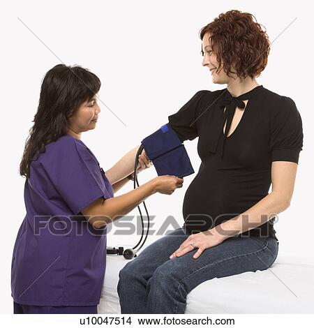 Pregnant Caucasian mid-adult woman having blood pressure checked by nurse. View Large Photo Image Picture - Pregnant Caucasian mid-adult woman having blood pressure checked by nurse.. Fotosearch