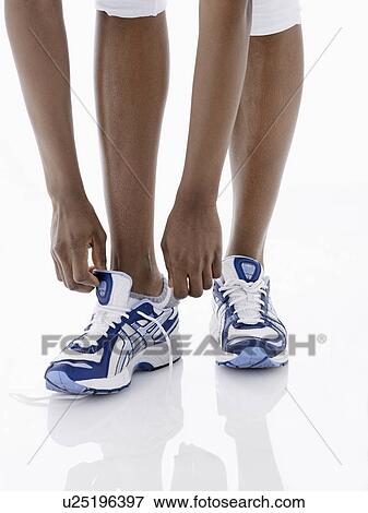 Female runner putting sneakers on (low section) View Large Photo Image Stock Photo - Female runner putting sneakers on (low section). Fotosearch
