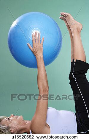 Mature woman exercising abdominals with Swiss ball View Large Photo Image Stock Image - Mature woman exercising abdominals with Swiss ball. Fotosearch