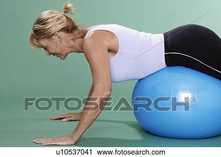 Mature woman exercising on Swiss ball View Large Photo Image Stock Image - Mature woman exercising on Swiss ball. Fotosearch