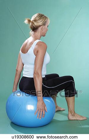 Mature woman exercising on Swiss ball (rear view) View Large Photo Image Stock Image - Mature woman exercising on Swiss ball (rear view). Fotosearch