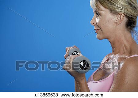 Mature woman exercising with dumbbells View Large Photo Image Stock Photo - Mature woman exercising with dumbbells. Fotosearch