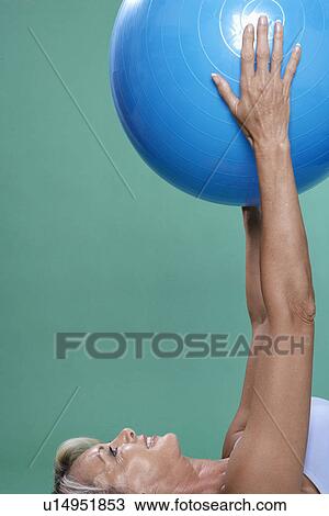 Mature woman exercising with Swiss ball View Large Photo Image Stock Image - Mature woman exercising with Swiss ball. Fotosearch