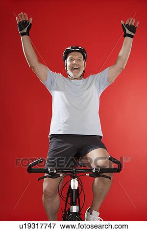 Stock Photo - Senior male cyclist celebrating. Fotosearch