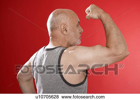 Stock Photo - Senior man flexing muscles. Fotosearch