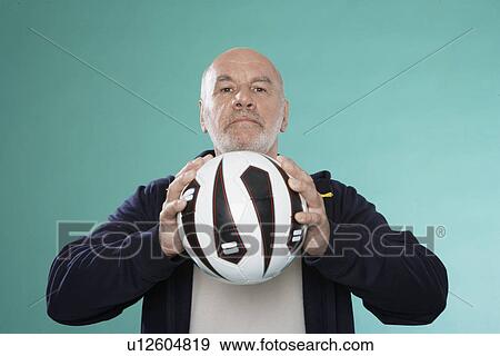 Senior man holding soccer ball View Large Photo Image Stock Photo - Senior man holding soccer ball. Fotosearch