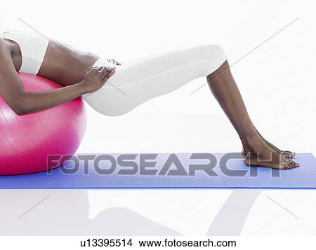 Woman exercising with Swiss ball (low section) View Large Photo Image Picture - Woman exercising with Swiss ball (low section). Fotosearch