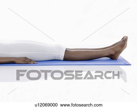 Young woman lying on exercise mat (low section) View Large Photo Image Stock Image - Young woman lying on exercise mat (low section). Fotosearch