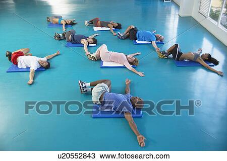 Stock Image - Group stretching on floor (high angle view). Fotosearch