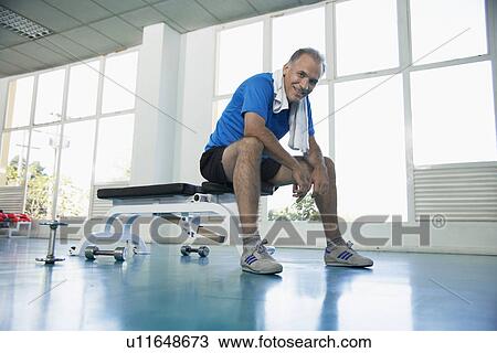 Man sitting on exercise bench View Large Photo Image Stock Image - Man sitting on exercise bench. Fotosearch