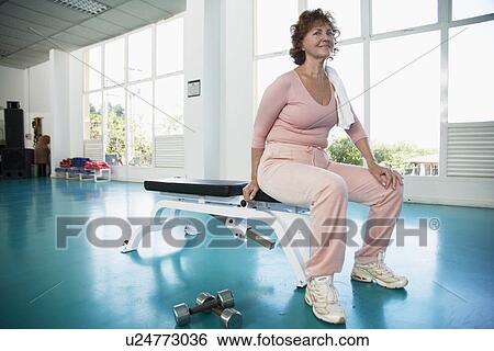 Mature woman sitting on exercise bench (portrait) View Large Photo Image Stock Photograph - Mature woman sitting on exercise bench (portrait). Fotosearch